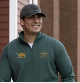 Man in an embroidered cap and quarter-zip