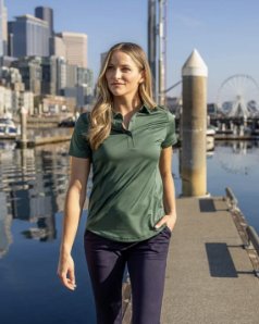 Woman in a performance polo on a city waterfront