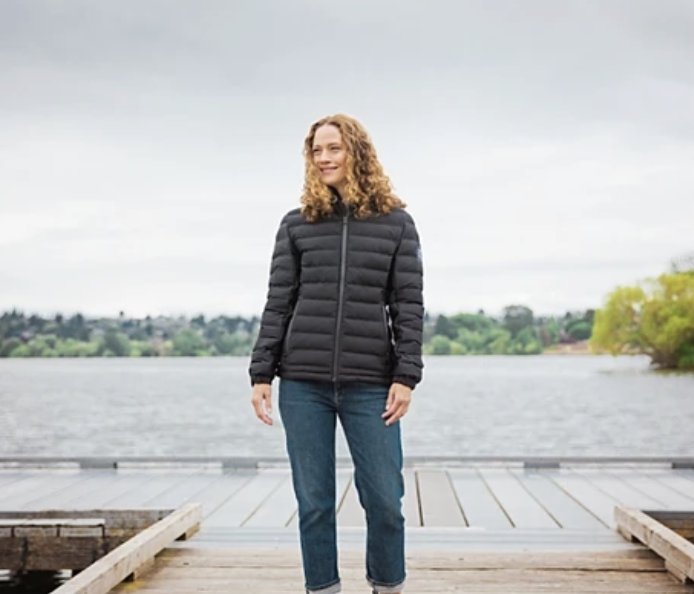 Woman on a dock wearing a black quilted corporate jacket